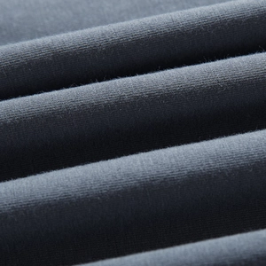 Macro shot of dark grey blue knitted cotton fabric with soft texture and refined stitching