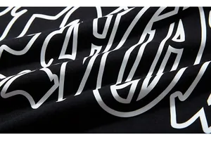 Close-up of white graphic print and high-density black knit texture on autumn hoodie