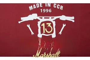 Macro shot of vintage biker print with motorcycle and tools on burgundy hoodie fabric
