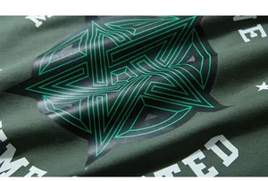 Close-up of geometric star print and white lettering on dark green cotton fabric