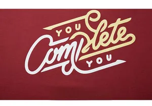 Detail of burgundy sweatshirt featuring vintage You Complete You and Montana print