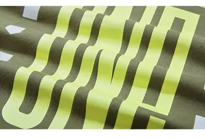 Detail of olive green knit fabric featuring vibrant neon yellow graphic screen print