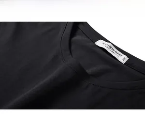Close-up of black cotton crew neck T-shirt collar with white size label and fine stitching