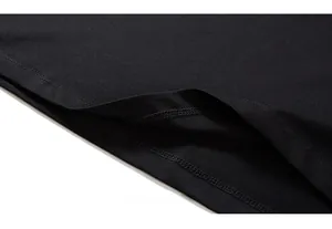 Close-up of double-needle stitching on the hem of a black cotton oversized t-shirt