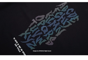Macro detail of iridescent reflective alphabet print on premium black cotton t-shirt fabric