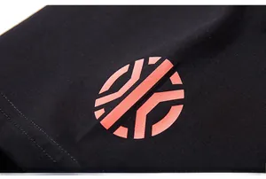 Détail du tissu en coton noir de qualité avec un logo géométrique orange vif imprimé