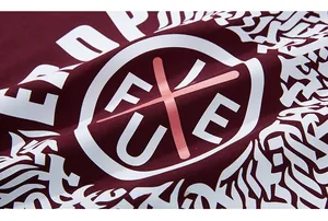 Détail du t-shirt en coton bordeaux avec logo circulaire blanc et élément X rose vif