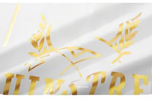 Macro view of gold foil wheat logo and metallic print on white cotton T-shirt