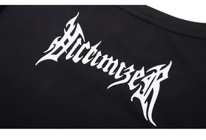 Gros plan de l'imprimé gothique Victimizer blanc sur un t-shirt noir en coton détaillé