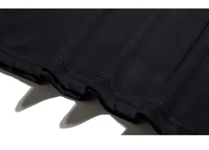 Detail of double-needle stitching on the hem of a black oversized knit cotton T-shirt