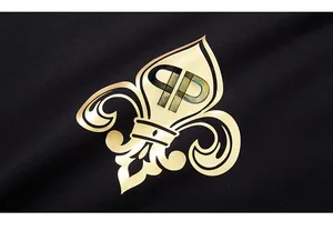 Detailed close-up of golden metallic logo print on black cotton t-shirt fabric