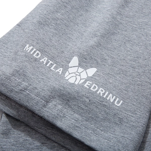 Close-up of grey cotton t-shirt featuring white geometric dog print and letter branding