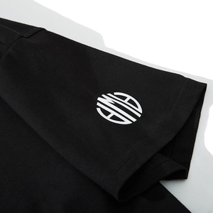 Détail de manche de T-shirt noir en coton avec logo blanc et couture double aiguille