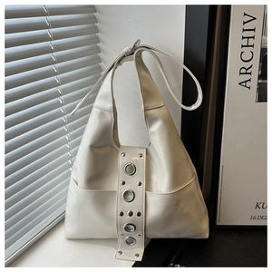 Détail du sac hobo en cuir blanc crème avec rivets argentés et œillets métalliques