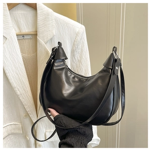 Detail of black leather crescent bag with silver buckle and embossed logo text
