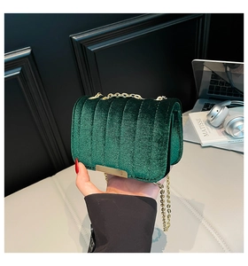 Detail of dark green quilted velvet crossbody bag with golden chain and metal lock