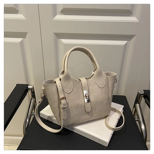 Detail of cream leather bucket bag with silver turn-lock clasp and fashion lettering