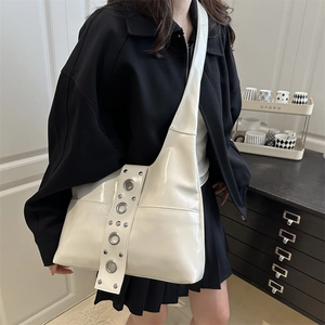 Sac fourre-tout crème en cuir verni brillant avec de grands œillets métalliques et bandoulière