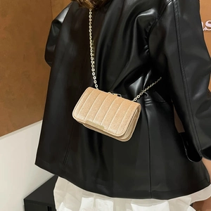 Champagne velvet crossbody bag with vertical quilting and elegant gold chain strap