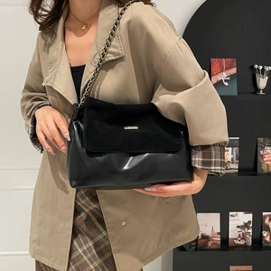 Retro black matte tote bag with gold chain strap shown on model in trench coat