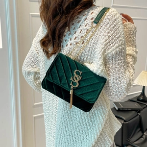 Deep green velvet shoulder bag with V-quilted pattern, golden chain and tassel charm