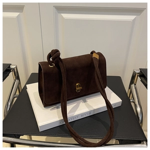 Detail of dark brown suede crossbody bag with gold lock and knotted shoulder strap