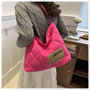 Vue détaillée du sac bandoulière en nylon matelassé magenta avec étiquette de mode