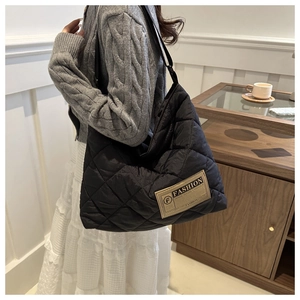 Détail du sac cabas matelassé noir avec étiquette vintage et coutures en losanges