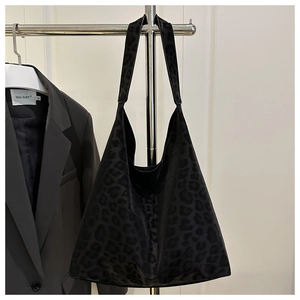Detail view of large grey leopard print hobo bag hanging on a minimalist steel rack