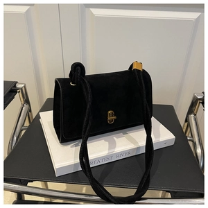 Detail of black suede crossbody bag featuring a vintage gold clasp and woven rope strap