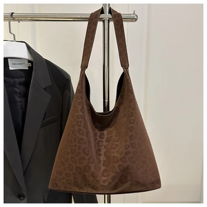 Detail of coffee leopard print tote bag with soft suede texture and wide shoulder strap