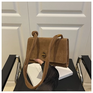 Detailed shot of brown frosted suede texture and gold twist-lock on stylish square bag