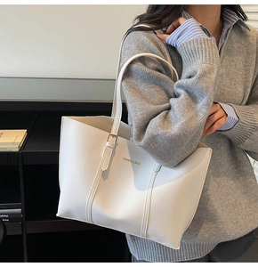 Détail du cabas blanc avec logo FASHION & BAGS et finitions métalliques de la bandoulière