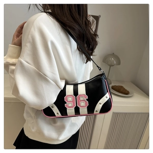 Detail of retro black faux leather underarm bag with pink trim and 96 varsity patch