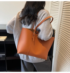 Détail d'un grand sac cabas orange-marron avec bandoulière réglable et boucle en métal