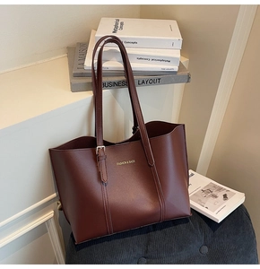 Gros plan détaillé du sac cabas en cuir marron foncé avec lettrage doré fin
