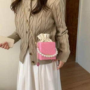 Pink crocodile-embossed mini bucket bag with pearl handle and golden chain strap
