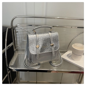 Silver woven texture mini backpack with adjustable straps on a minimalist display