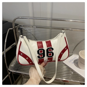 Detail of retro white underarm bag with red stripes, silver rivets and number 96 patch