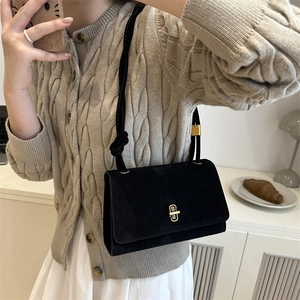 Black suede crossbody bag with gold metal lock and braided strap shown in lifestyle mirror selfie