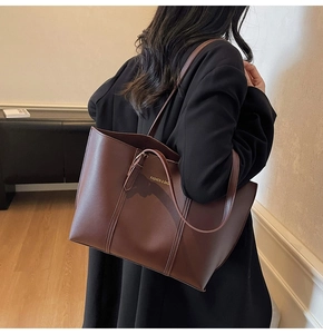 Détail d'un grand sac cabas marron foncé en cuir PU avec lettrage de mode doré