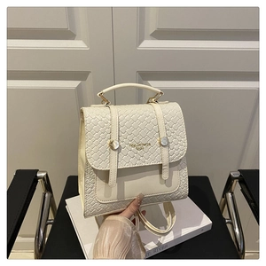 Detail of off-white backpack featuring woven texture flap and metallic closure on leather