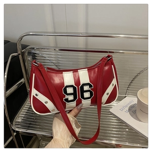 Detail of red and white vintage sport shoulder bag with number 96 patch on a shelf