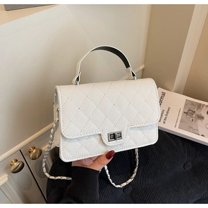 Close-up of ivory white quilted leather crossbody bag with metal twist lock and chain strap