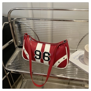 Detail view of red and white sporty leather underarm bag with number 96 and silver rivets