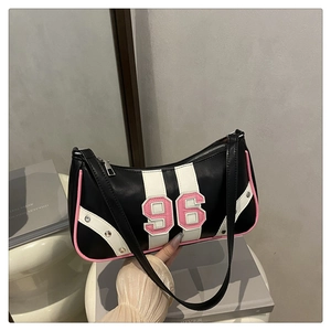 Detail of retro black shoulder bag with pink number 96 patch and silver rivets