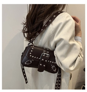 Detail van donkerbruine vintage punk tas met zilveren oogjes en metalen gesp
