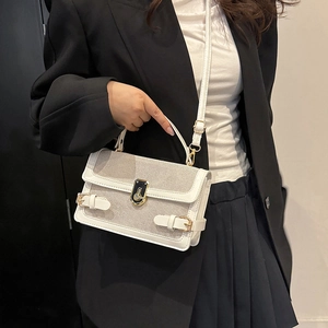 White textured crossbody bag with mesh detail and gold hardware on model