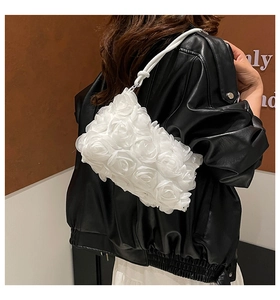 Detail of 3D fabric flower petals on a white fashion handbag with leather strap