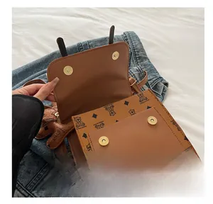 Close-up of brown PU leather backpack featuring dual magnetic snap button closures